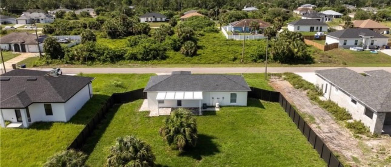 Vista aérea de un vecindario del suroeste de Florida con casas nuevas y terrenos vacíos